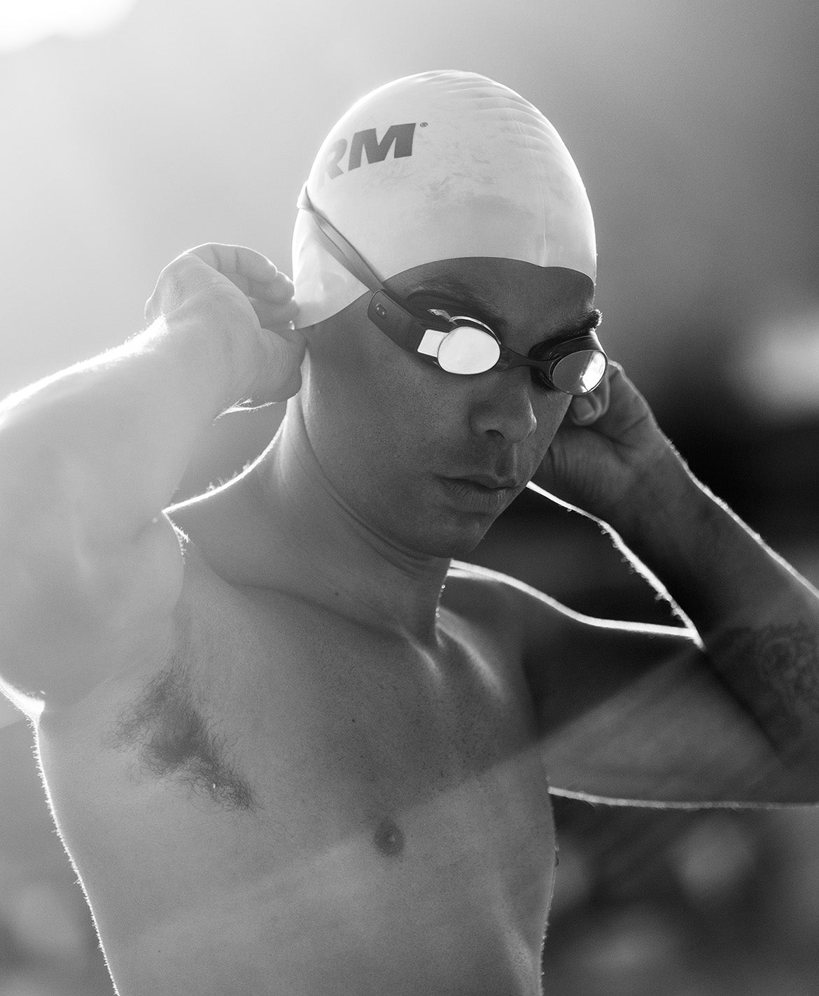 a swimmer with swim goggles and swim cap on head