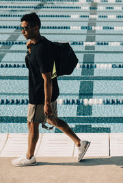 Man walking beside swimming pool